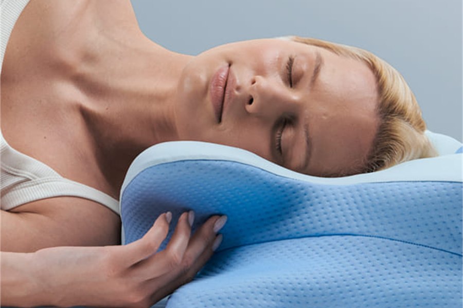 A woman resting comfortably on the ergonomic memory foam pillow